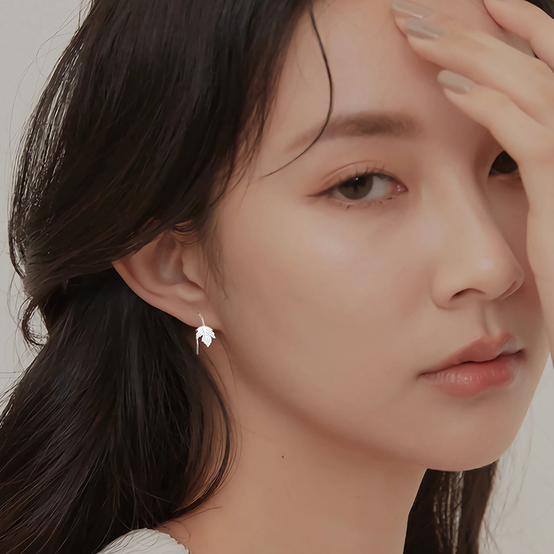 Maple leaf earrings worn by female model