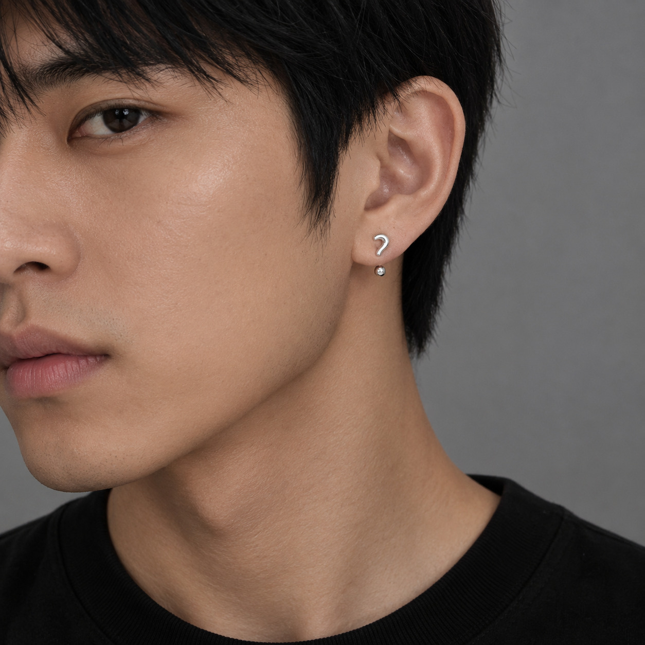 Minimalist silver punctuation earrings worn by male model