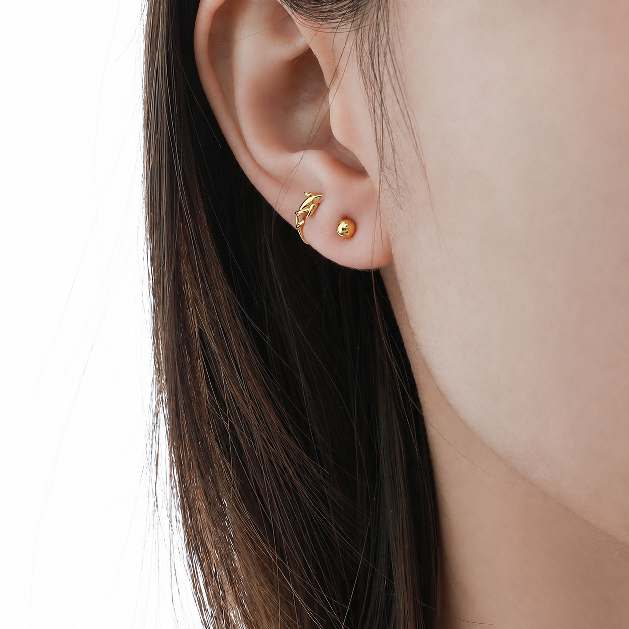 Moana N°2 Gold ball stud earring worn on ear, front view