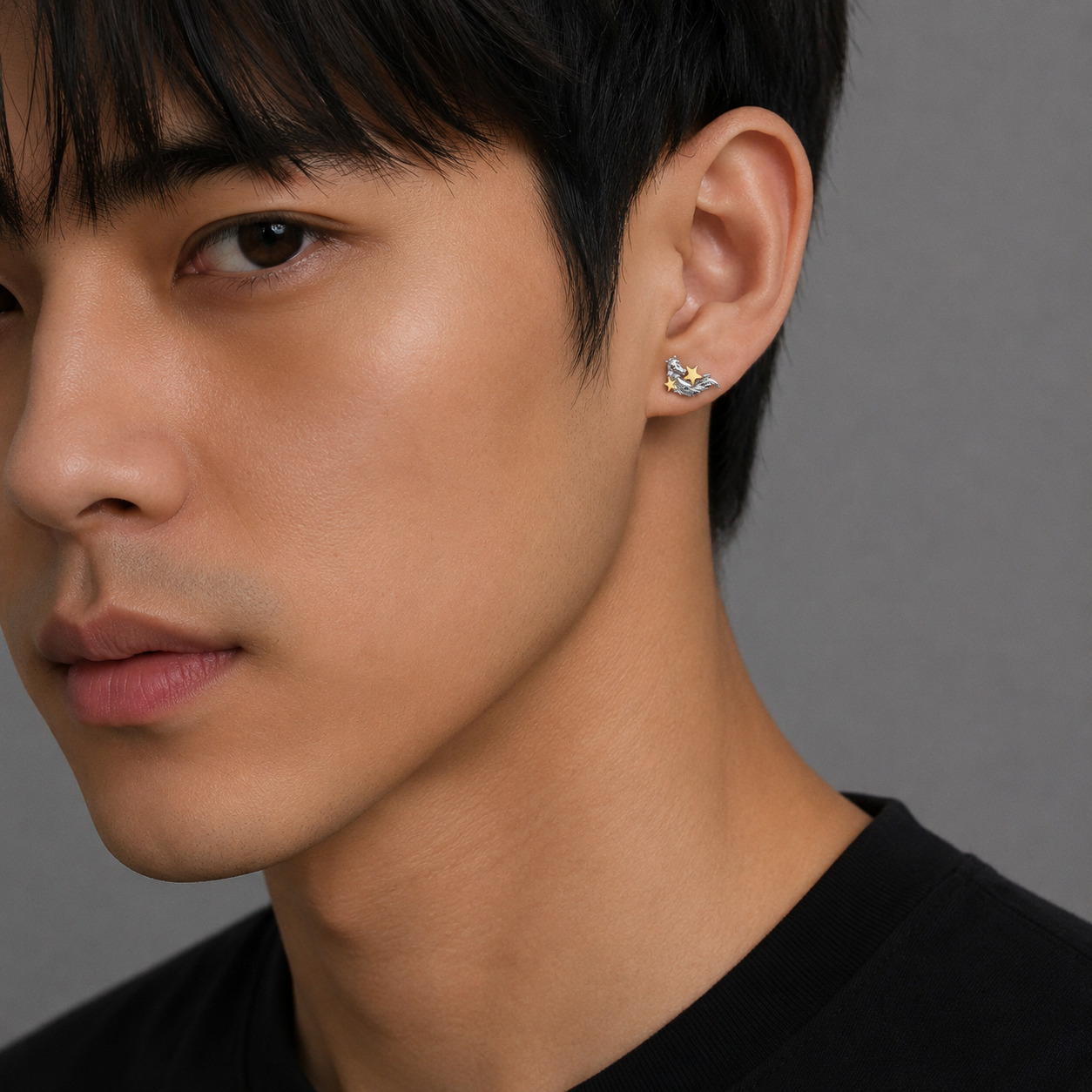 Silver horse earrings with gold stars worn by male model