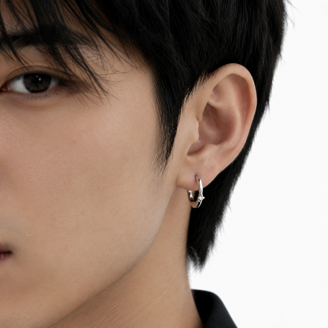 Side profile of  a male model wearing Starla hoop earrings