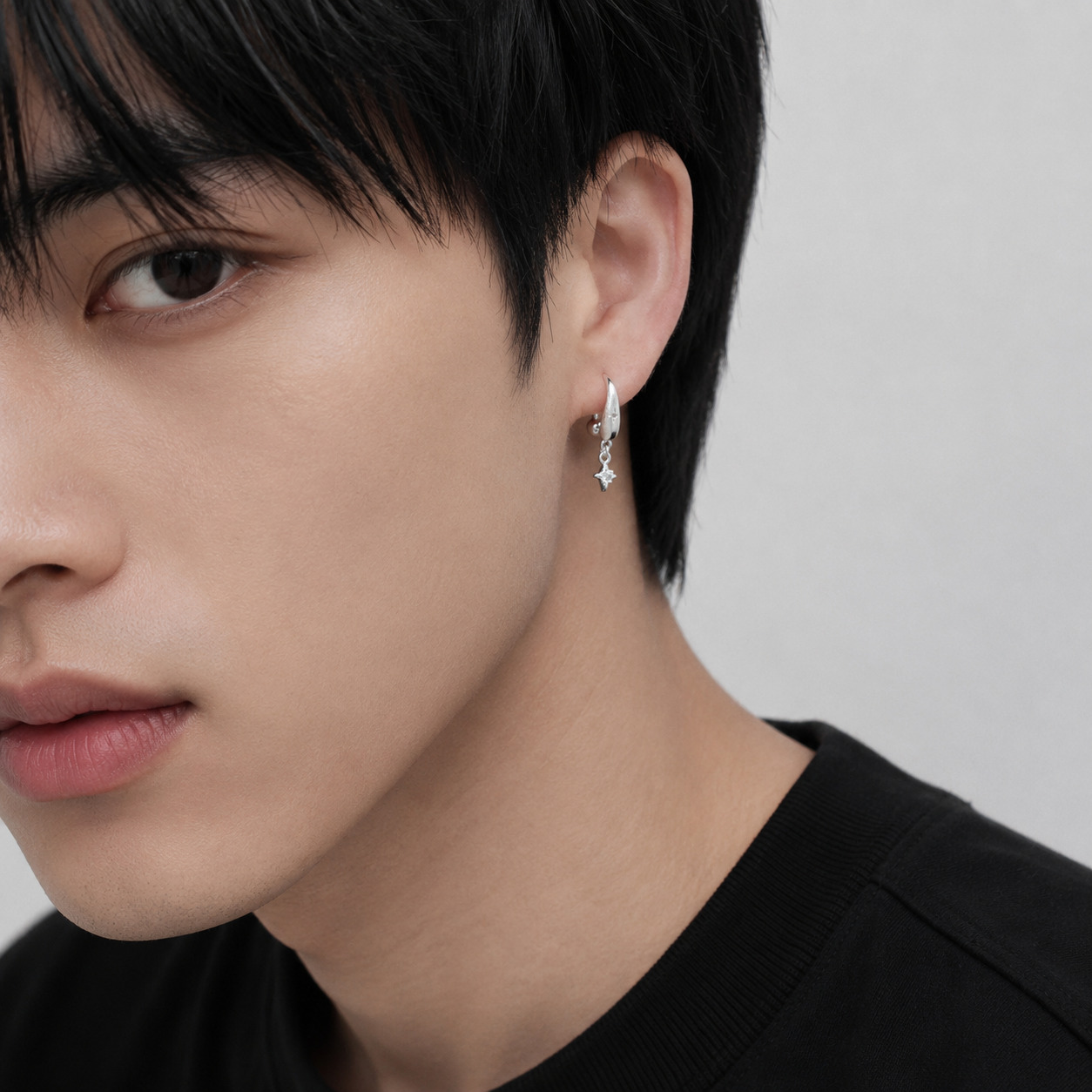Close-up of Starla N°5 Ear Studs in silver on a male model