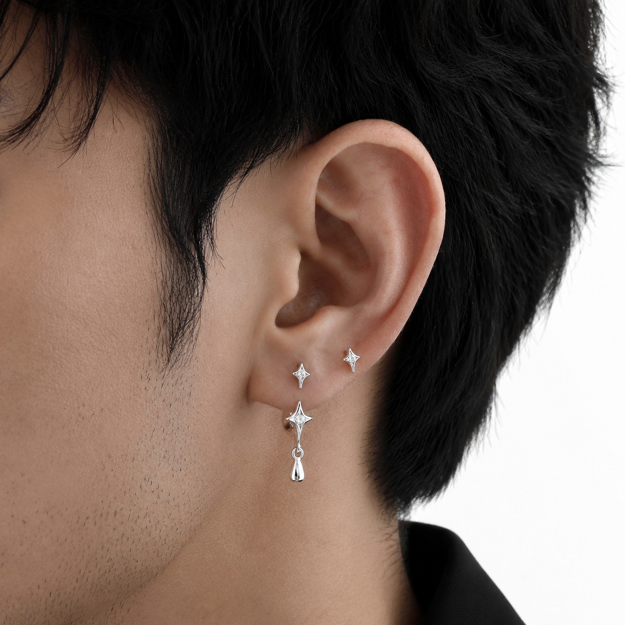 Starla N°6 Ear Studs worn on a man's ear, dangling drop detail
