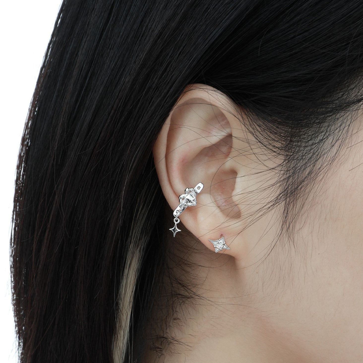 Starla N°8 silver star earrings worn on ear