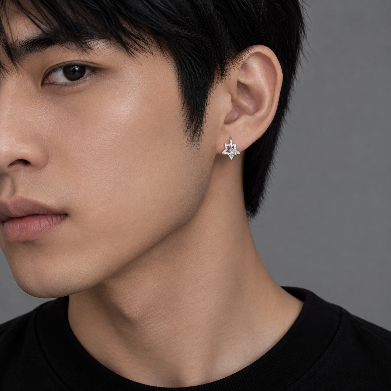 Sterling silver star hoop earring worn by male model