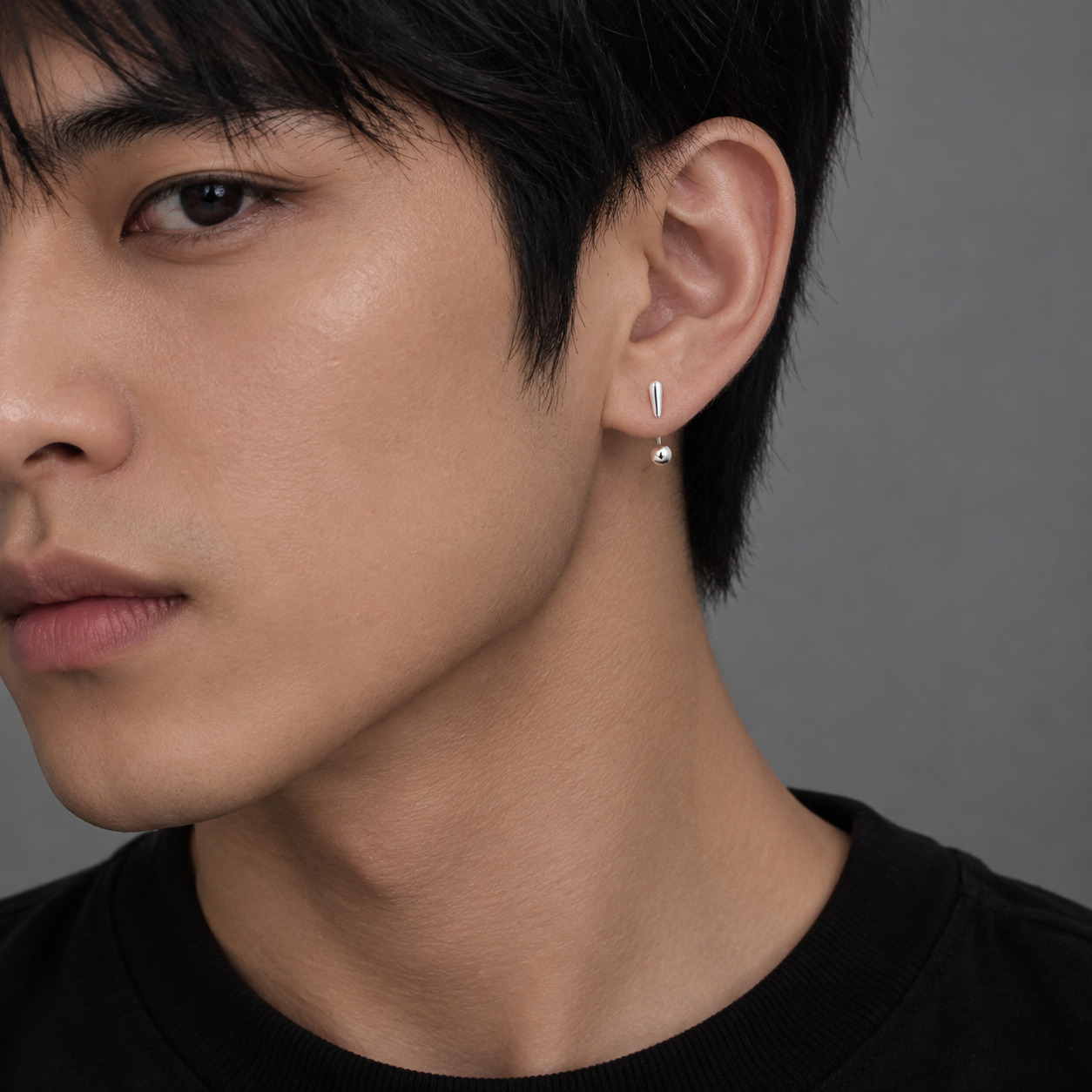 Unique silver statement earrings worn by male model