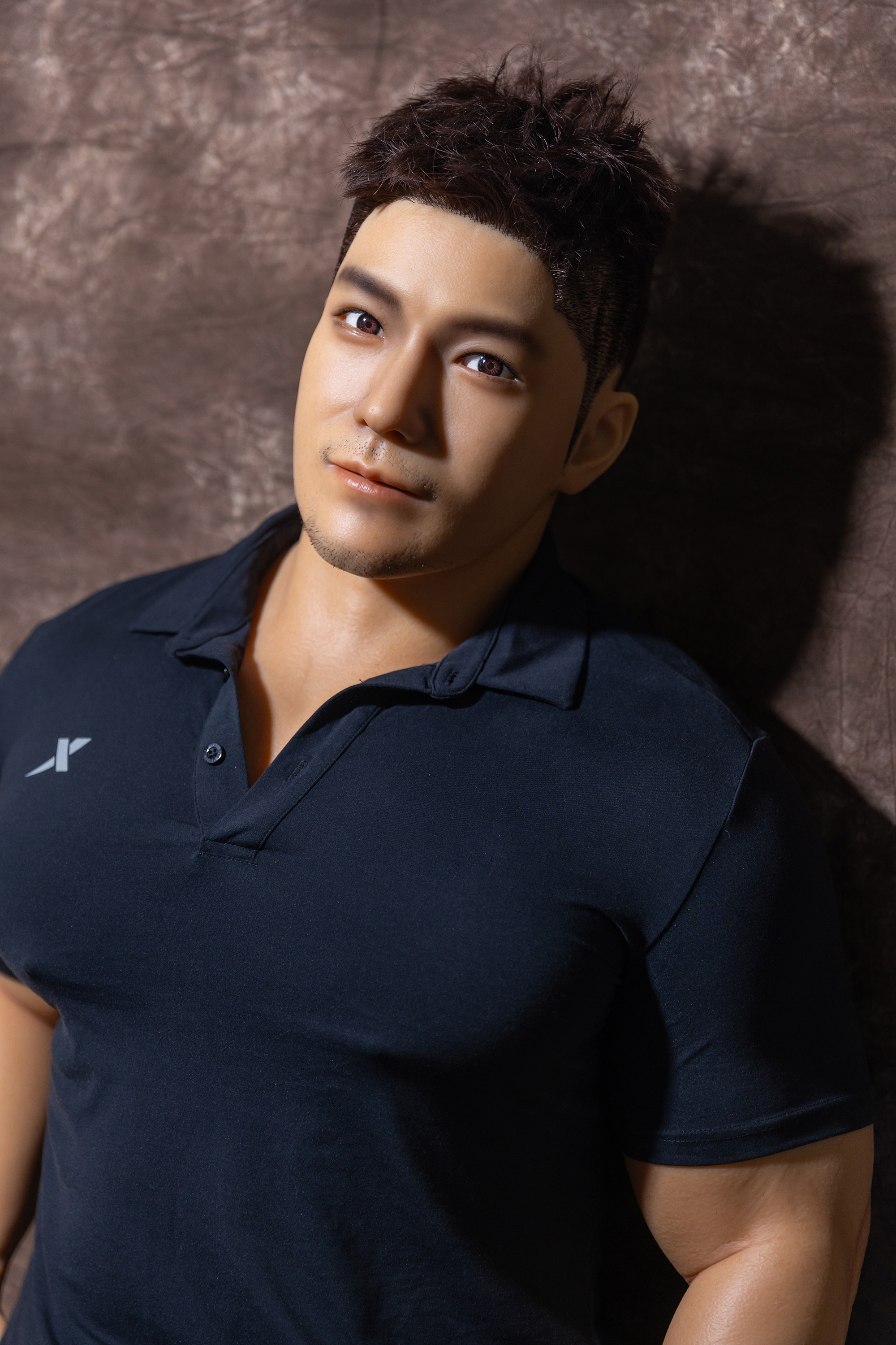 Male sex doll, face close-up, navy polo shirt