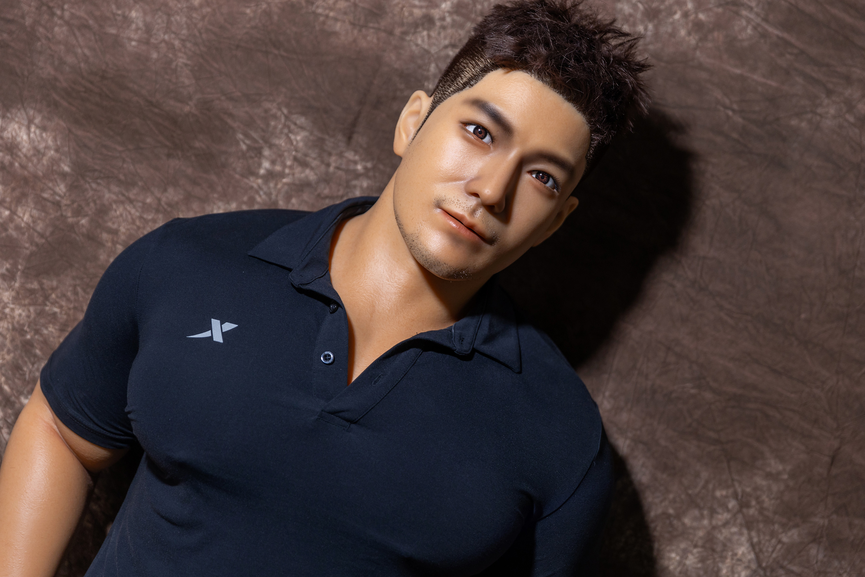 Realistic male sex doll, wearing black polo shirt