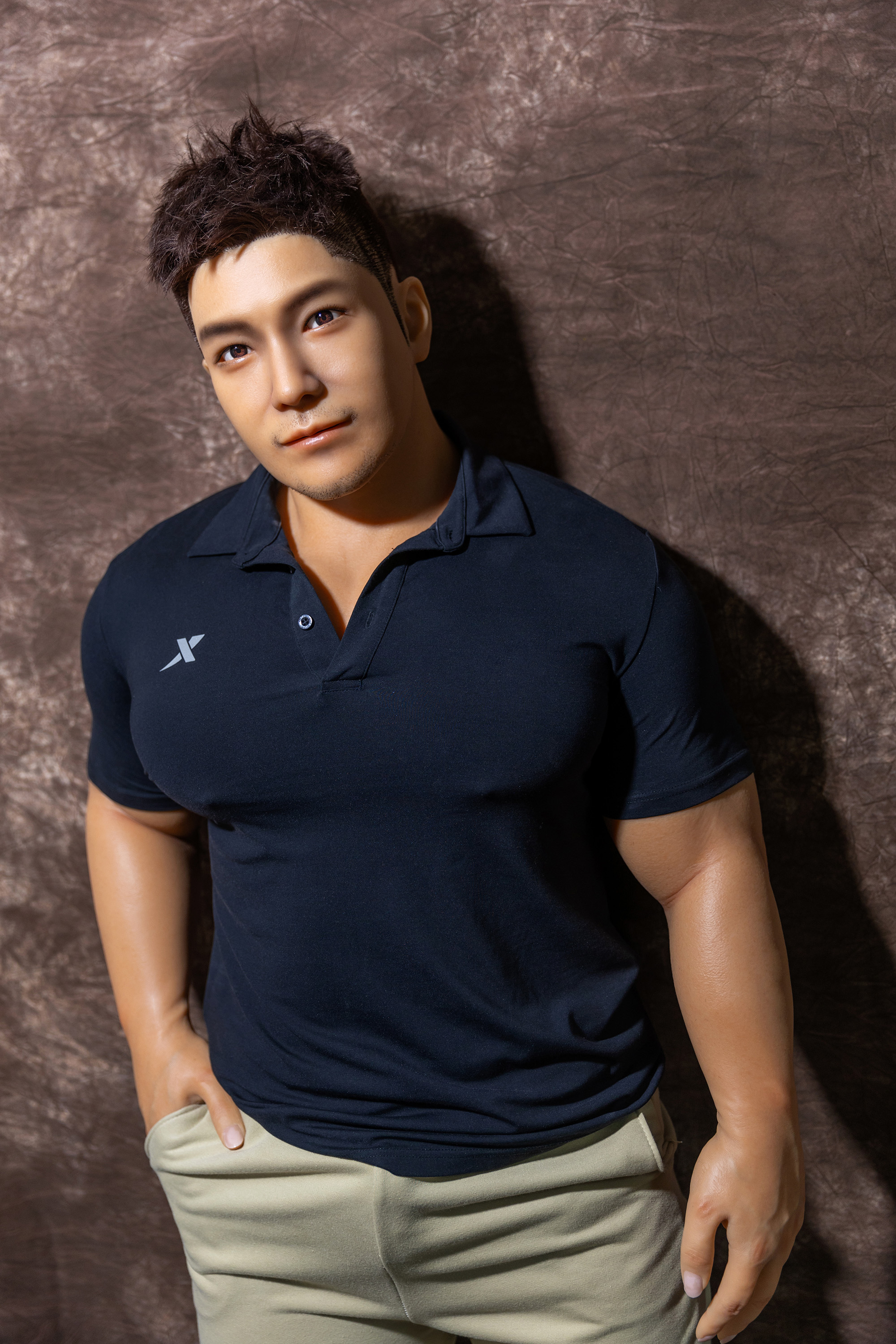 Male sex doll in navy polo shirt and beige pants