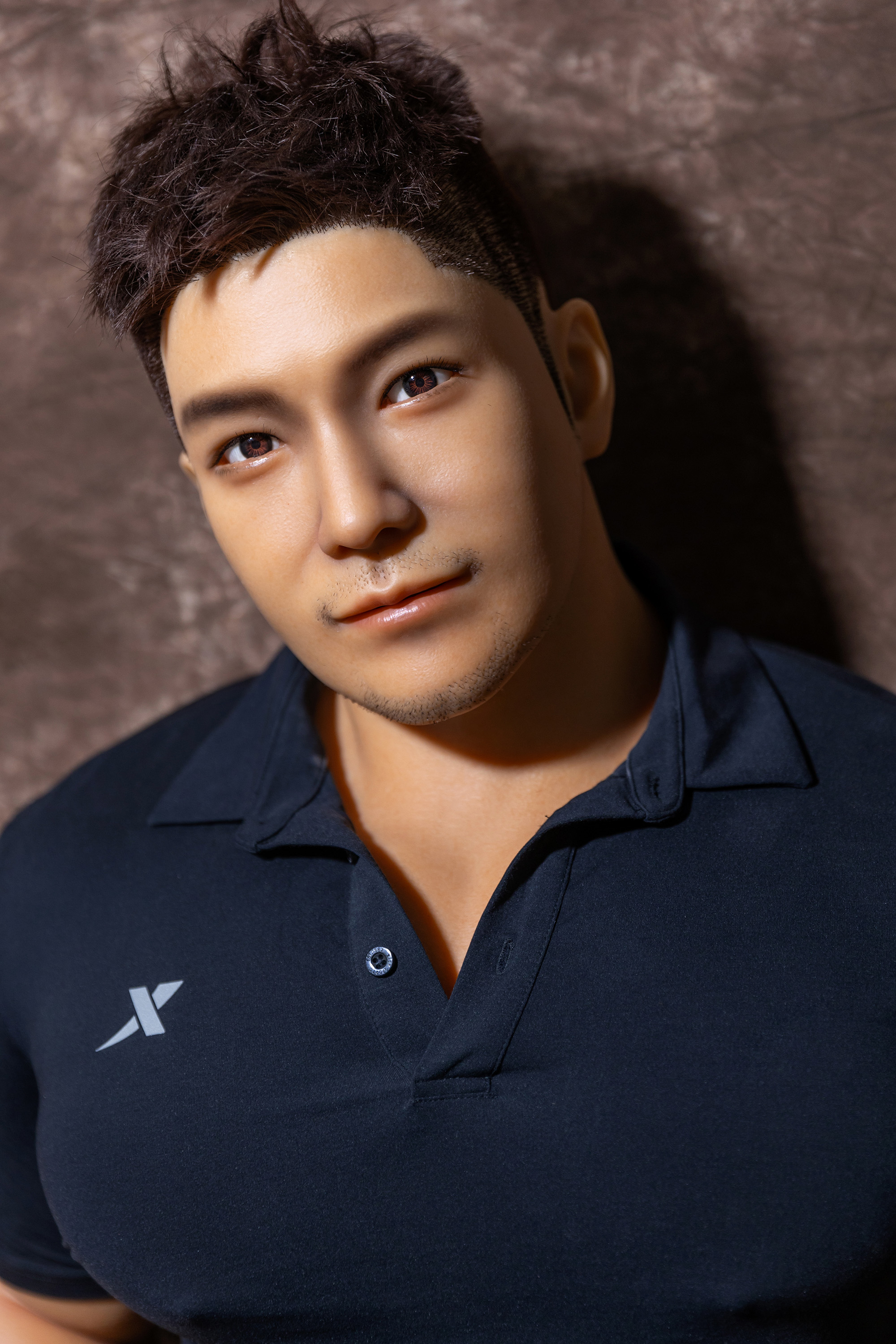 Realistic male sex doll, close up of face, wearing navy polo