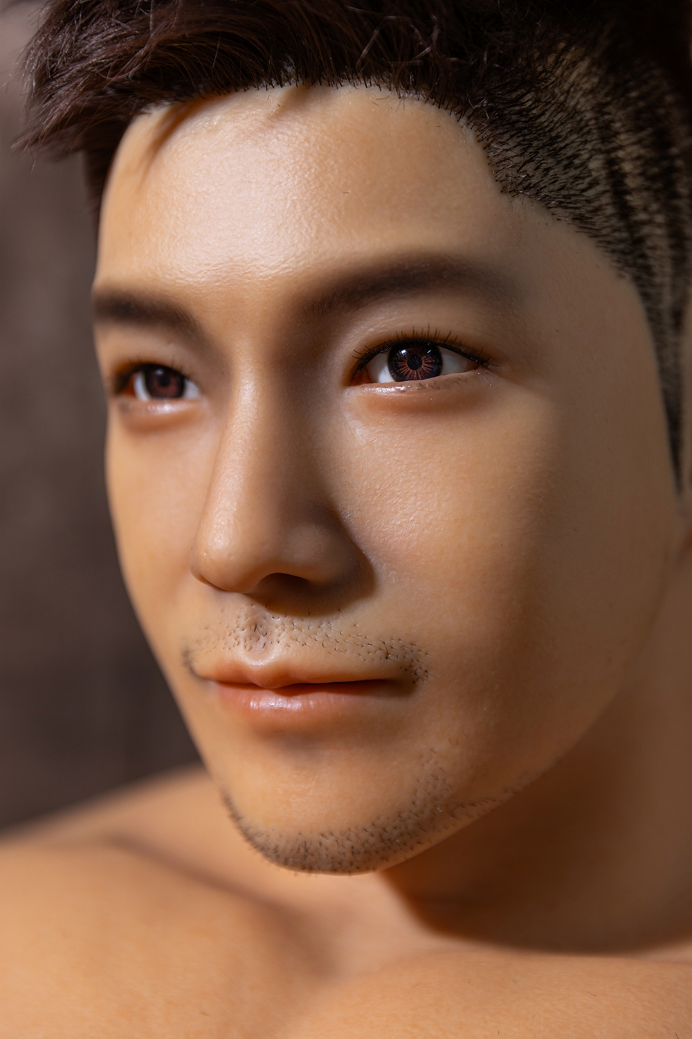 Male sex doll face close-up, realistic skin details.