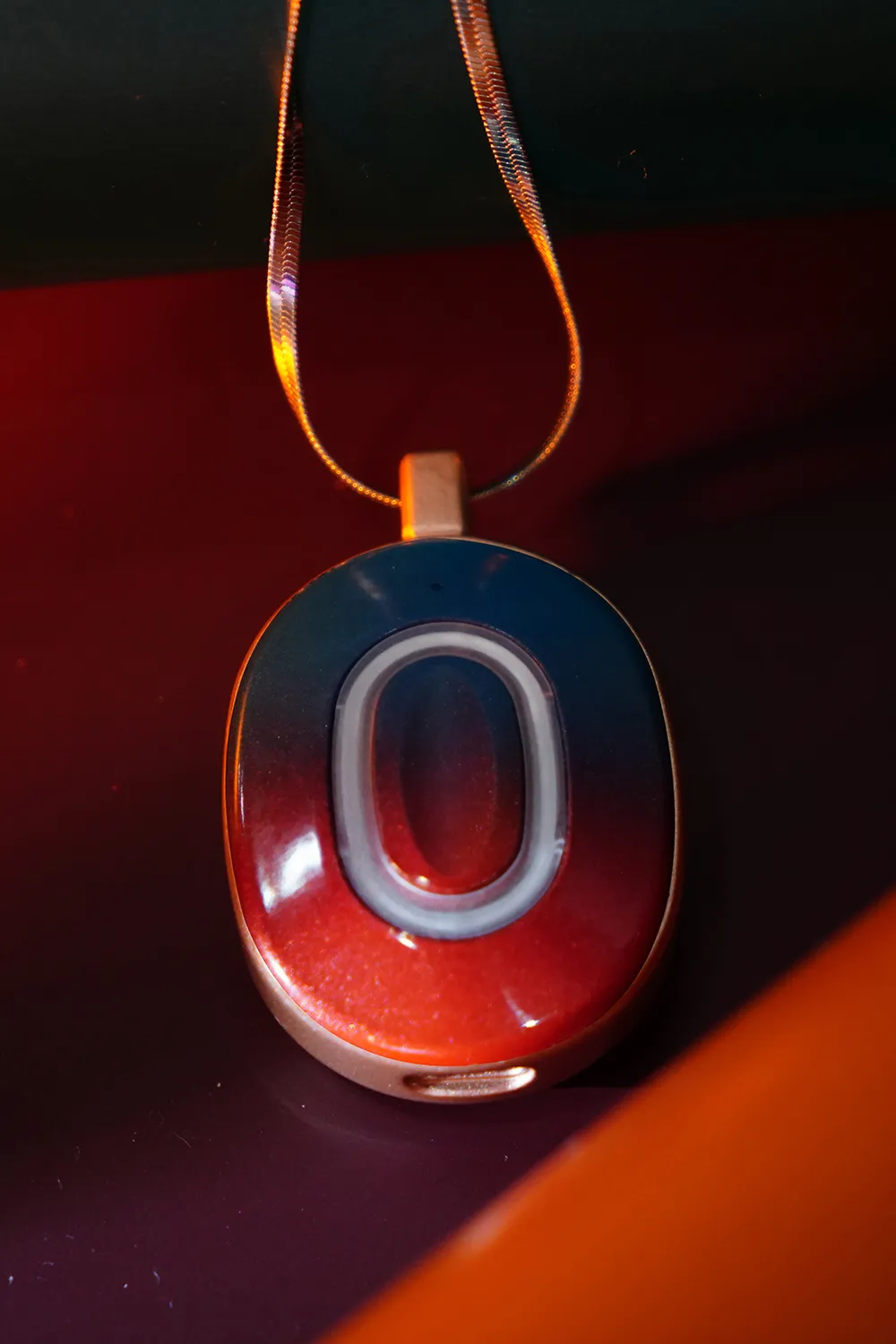 AI Box pendant with a gradient design, featuring a metallic loop for a chain.