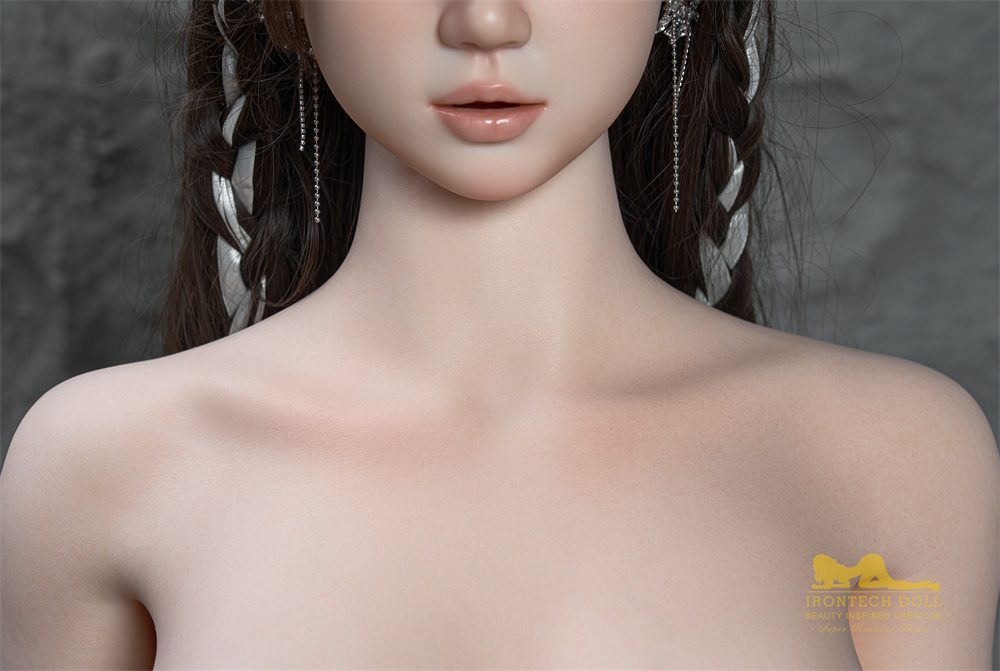 Close-up of Nia sex doll's face, showcasing earrings and braided hair.