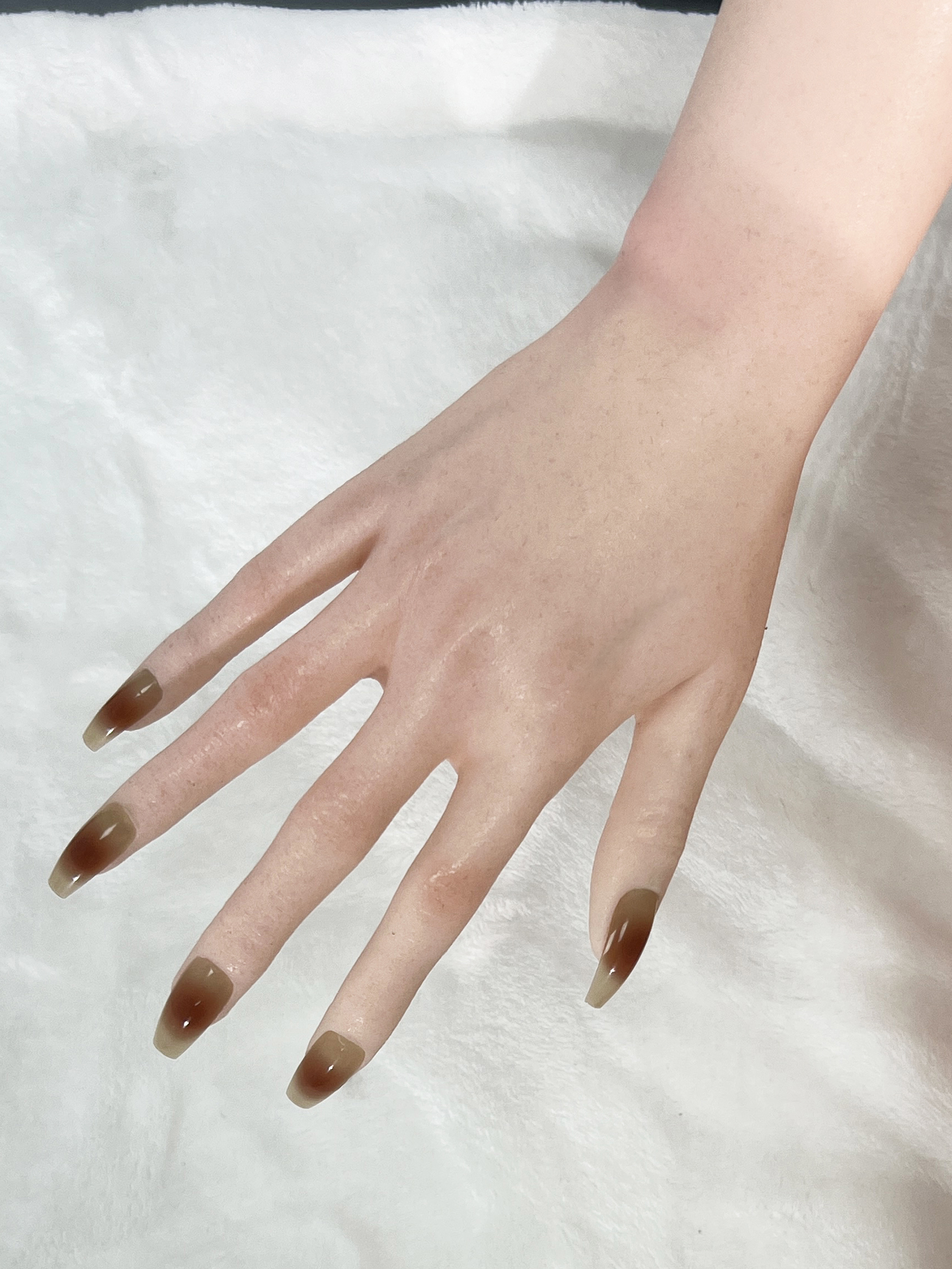 Realistic sex doll hand with long brown ombre nails
