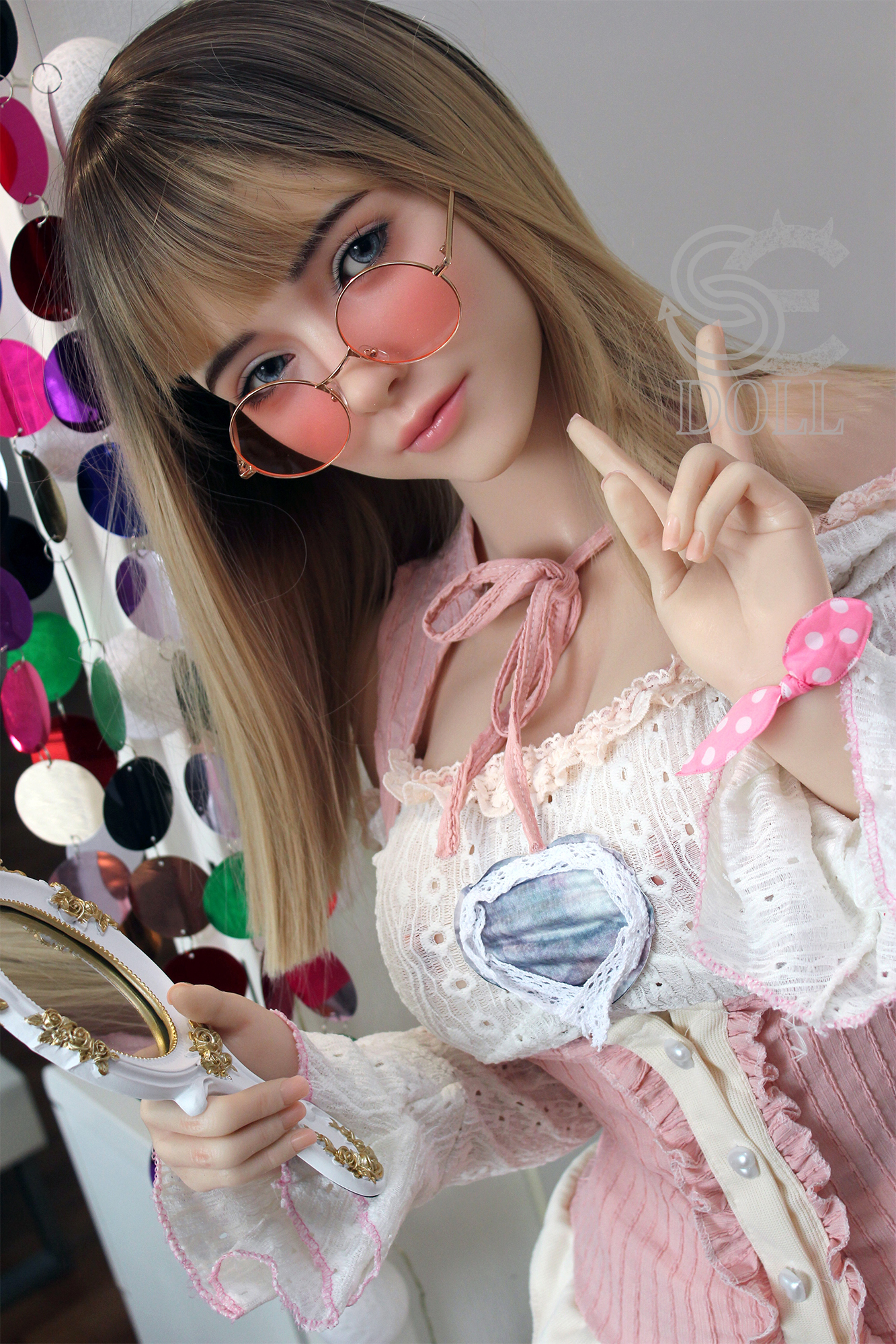 Annika.G silicone doll wearing pink glasses, holding mirror