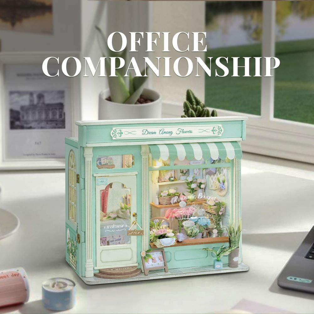 Below the main shop, the image displays four separate, detailed assemblies that are part of the kit:
A small flower cart or display box.
A white shelving unit with a watering can.
A three-tiered display shelf holding framed pictures and tiny plants.
A wooden crate overflowing with blue and purple flowers.