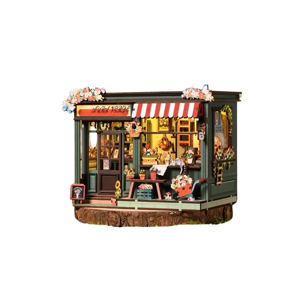 The shop features a dark green facade with a large display window and a red-and-white striped awning. It is highly detailed with tiny potted plants, hanging baskets, and floral arrangements.