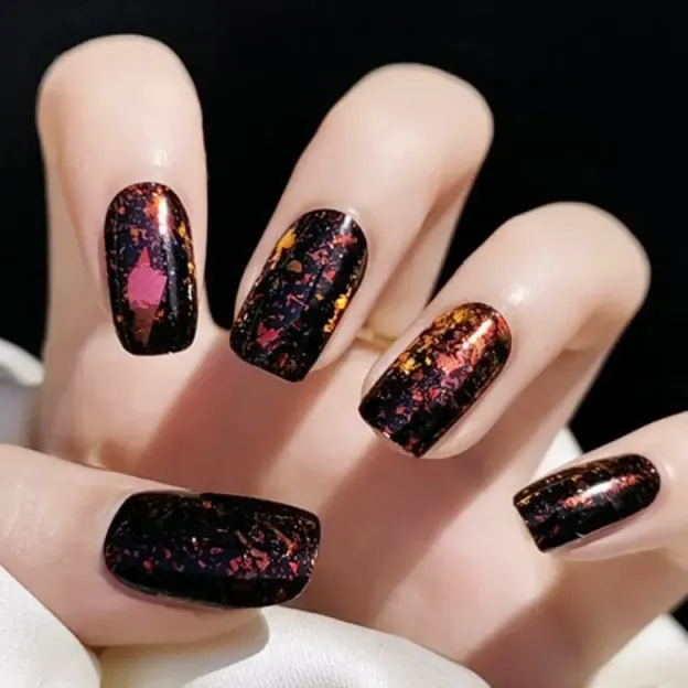 Autumn Fire Gel Nail Wraps with a bold black base and shimmering orange and gold metallic flakes for a fall-inspired manicure.