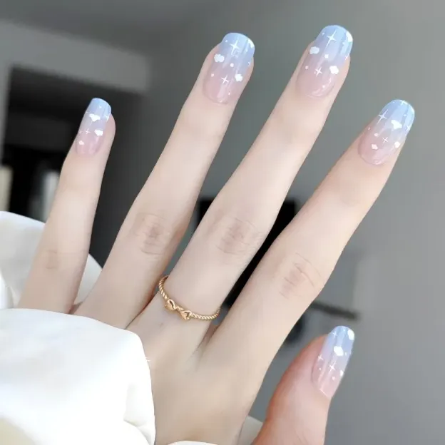 Dreamy Sky Gel Nail Wraps featuring a pastel blue gradient design with delicate clouds and shimmering stars for a celestial-themed manicure.