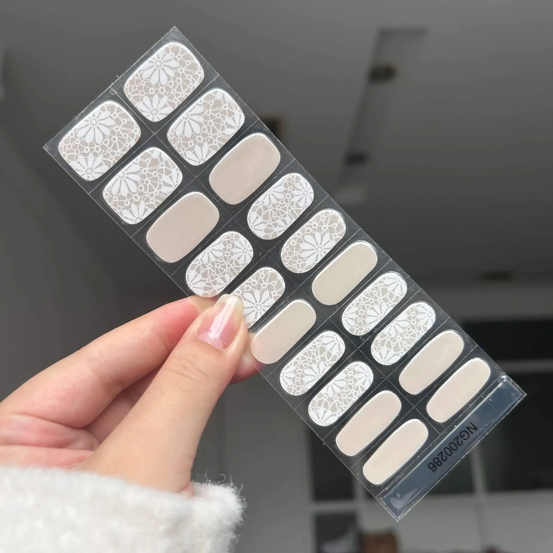 Floral elegance gel nail wraps featuring delicate white flower designs on a neutral background, ideal for weddings or romantic occasions.