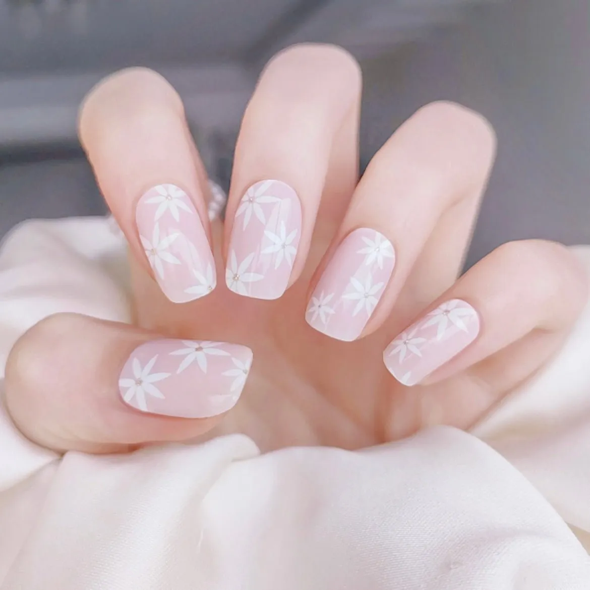 Gentle Pink Daisies Gel Nail Wraps featuring delicate white daisies on a pastel pink base for elegant semi-cured gel nail art.