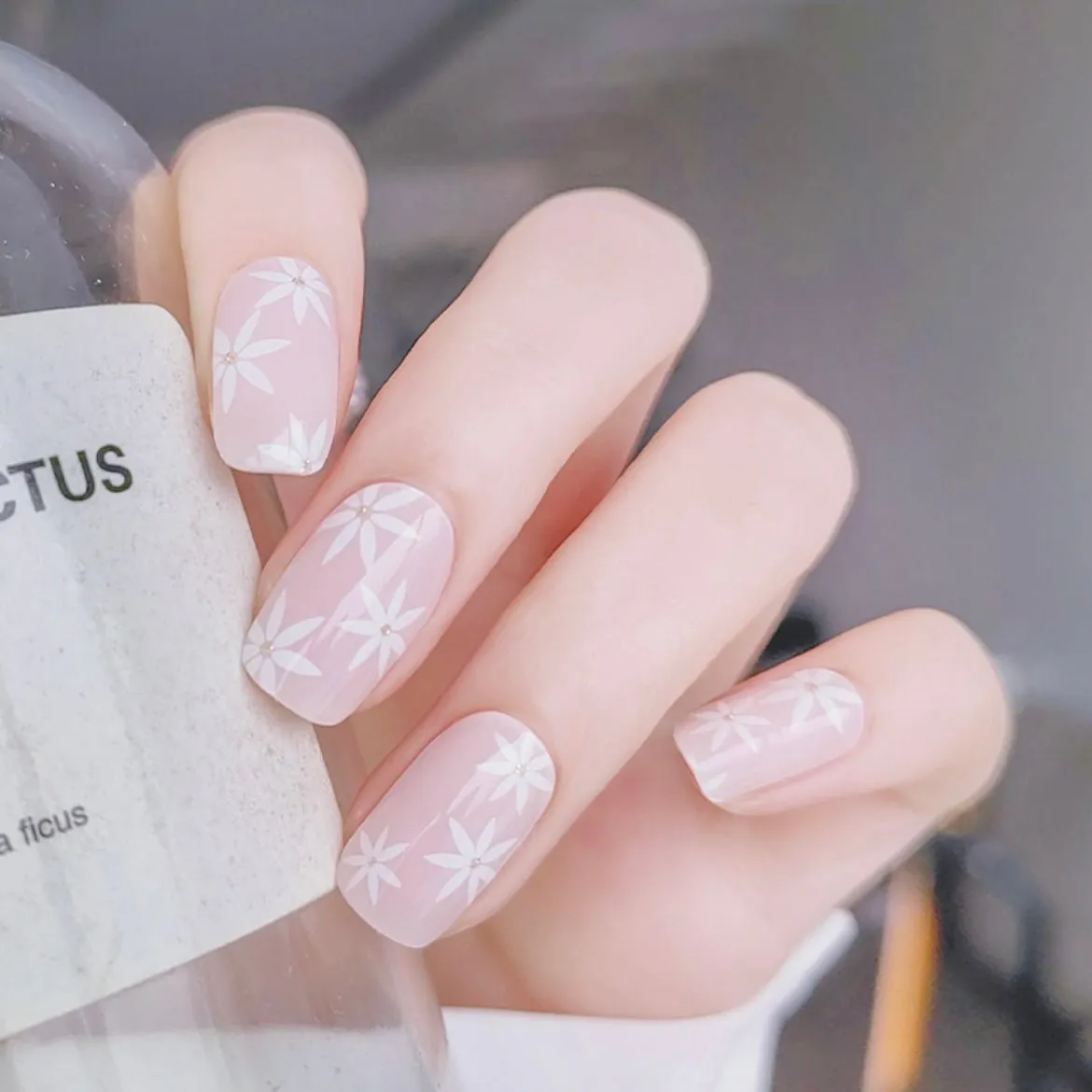 Gentle Pink Daisies Gel Nail Wraps featuring delicate white daisies on a pastel pink base for elegant semi-cured gel nail art.