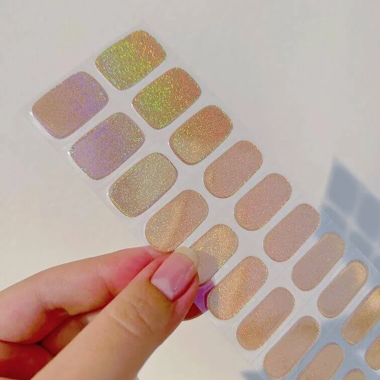 Golden holographic nude gel nail wraps with shimmering sparkle for a chic manicure.