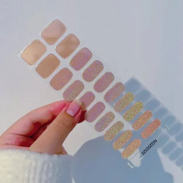 Golden holographic nude gel nail wraps with shimmering sparkle for a chic manicure.
