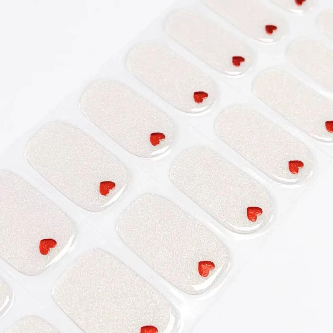 Heart Accent Gel Nail Wraps with a shimmering base and a delicate red heart detail for semi-cured gel manicures.