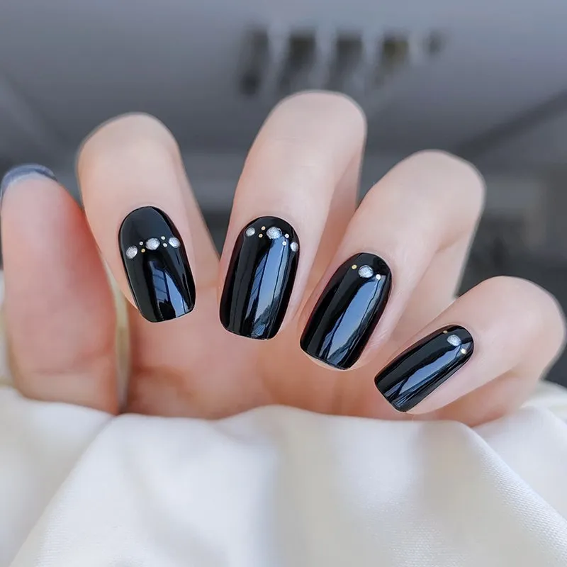 Midnight Sparkle Gel Nail Wraps featuring a black base with rhinestone accents for a bold and elegant manicure.