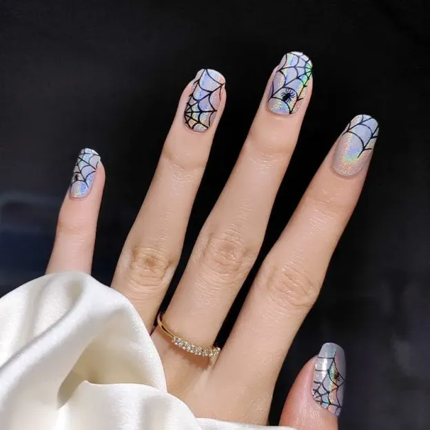 Spider Glow Gel Nail Wraps with bold black spider web designs and holographic accents for a spooky yet chic nail art look.