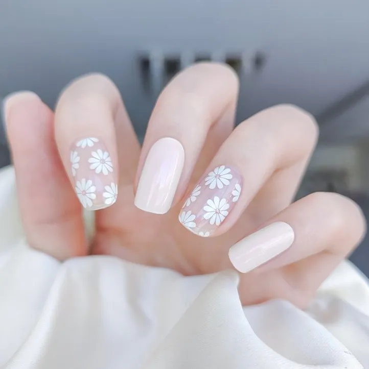 Spring Daisy Gel Nail Wraps with delicate white daisy patterns on a transparent base for a fresh and elegant manicure.