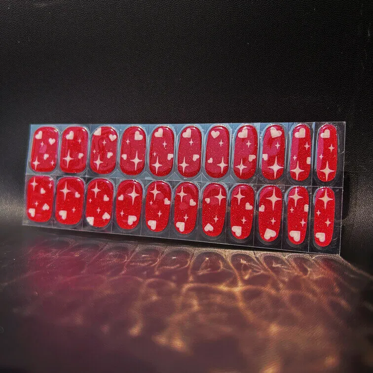Valentine red heart gel nail wraps with sparkling star and heart patterns for a romantic manicure.