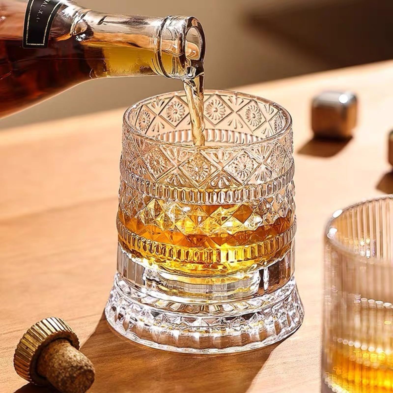 Pouring whiskey into the glass with other glasses and a cork nearby