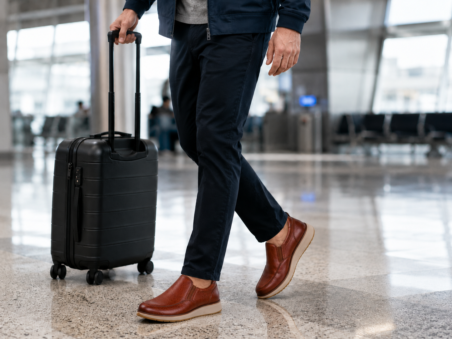 Mature man wearing StepReady brown leather loafers while walking through an airport with luggage