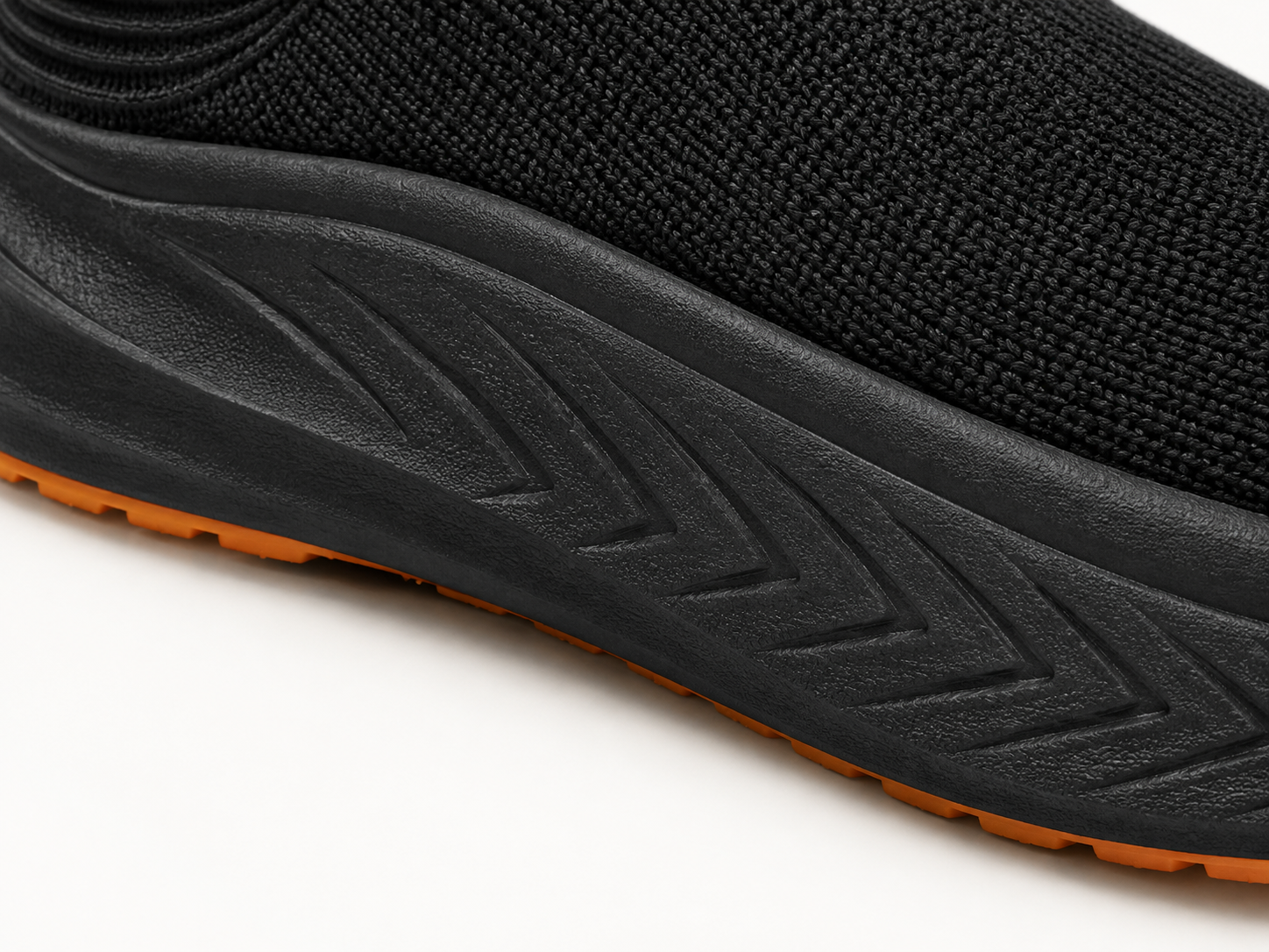 Black MD midsole detail with sculpted grooves and orange outsole edge
