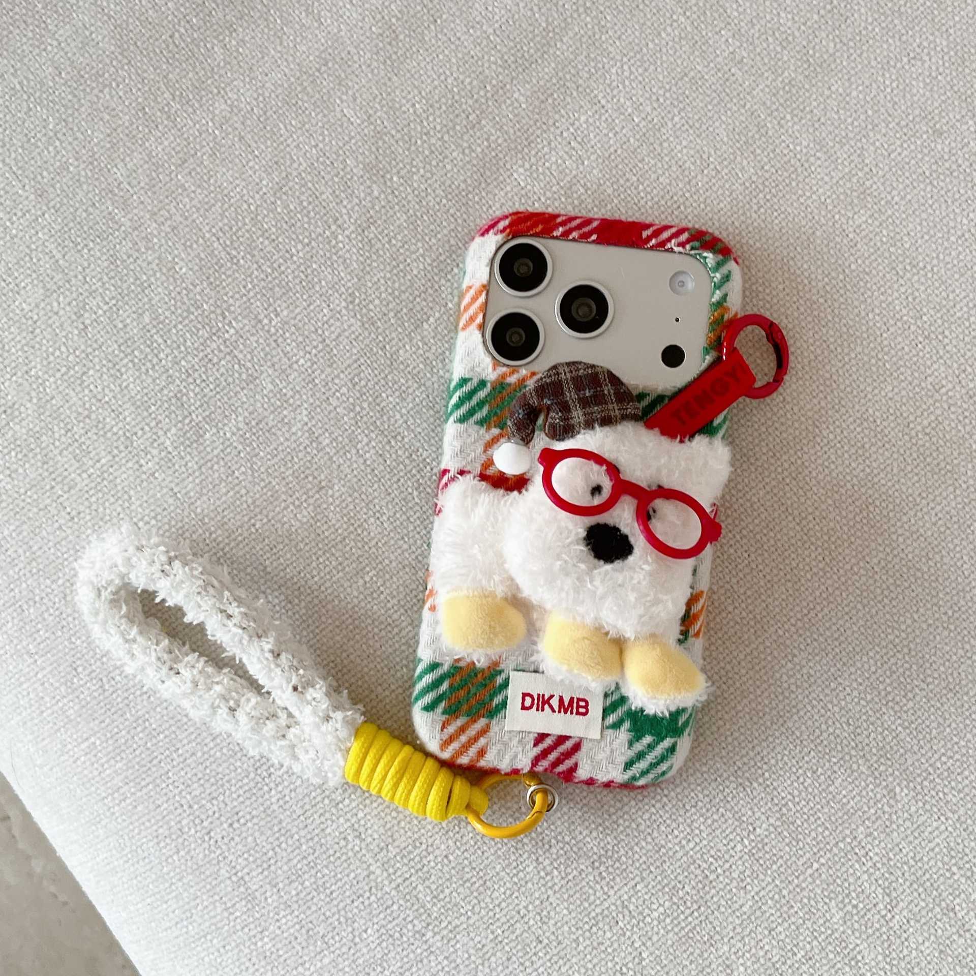 Cute plush dog-shaped phone case with lanyard for iPhone.