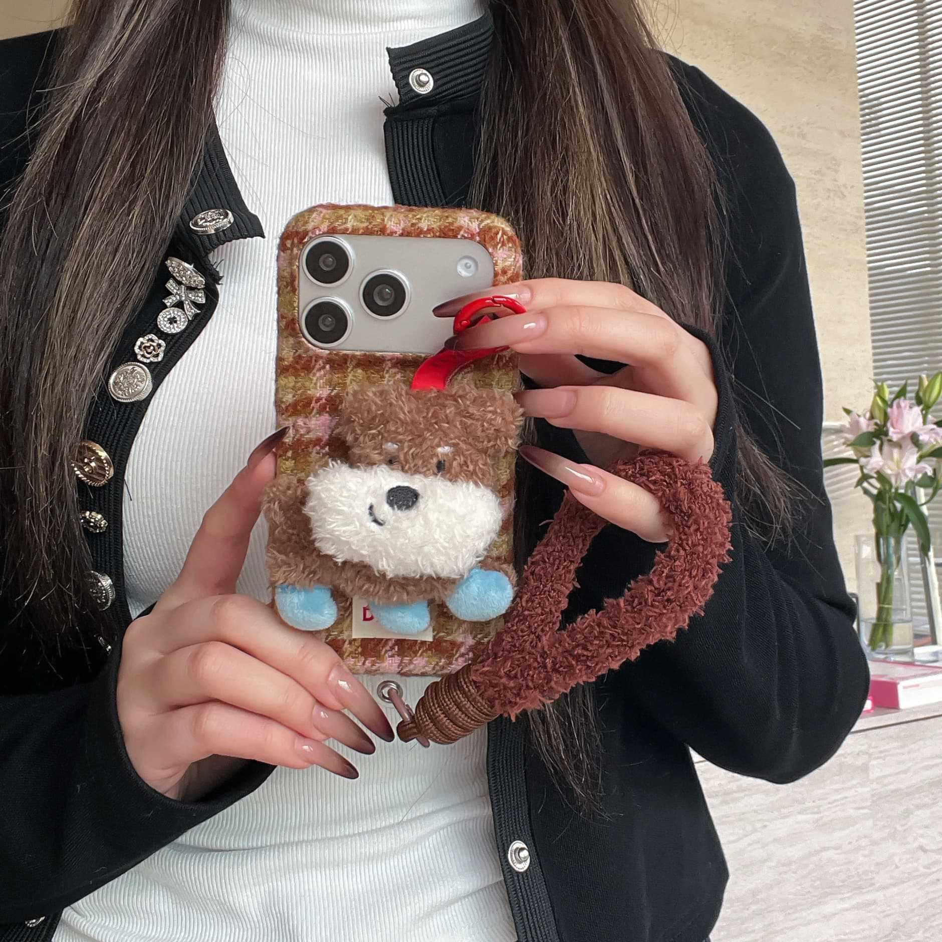 Cute plush dog-shaped phone case with lanyard for iPhone.
