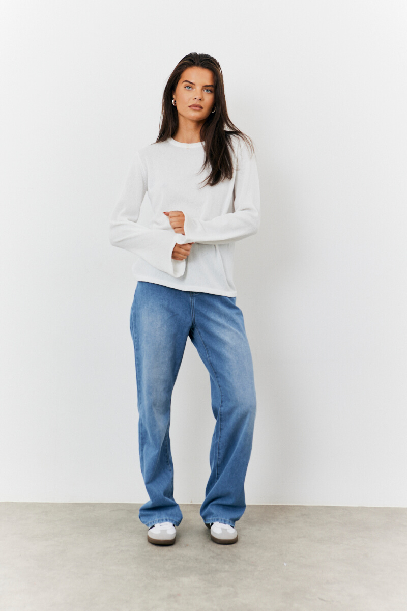 White textured long sleeve top + Straight leg blue jeans + Contrast stripe trainers