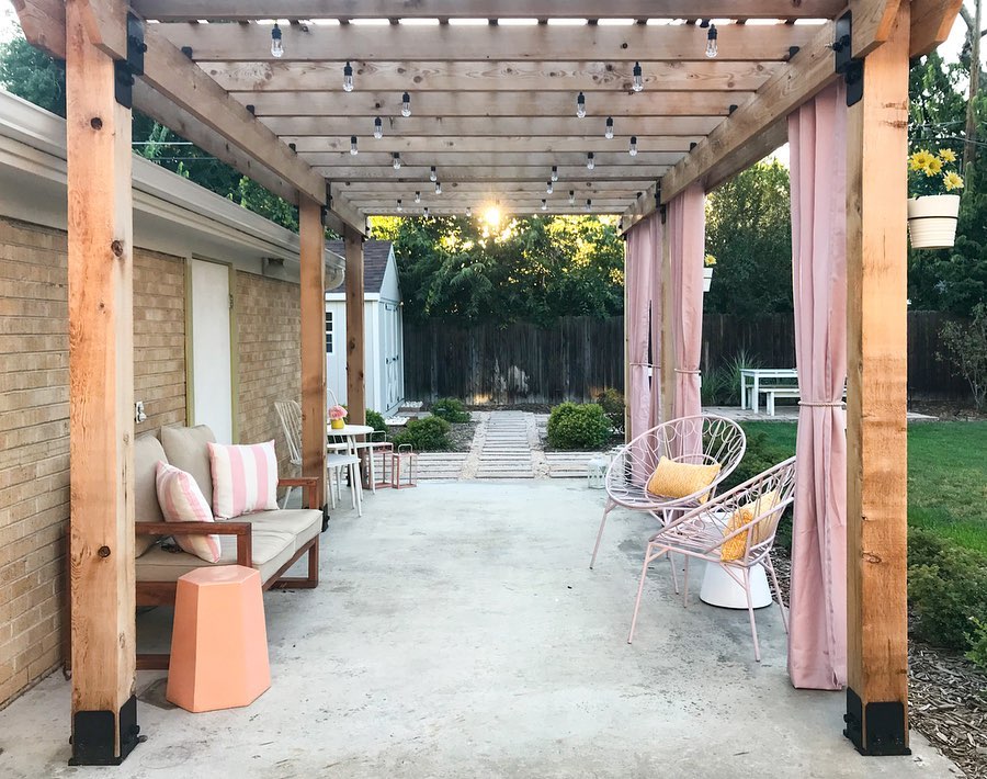 Pink Outdoor Curtains tied back on the side of a wooden backyard gazebo