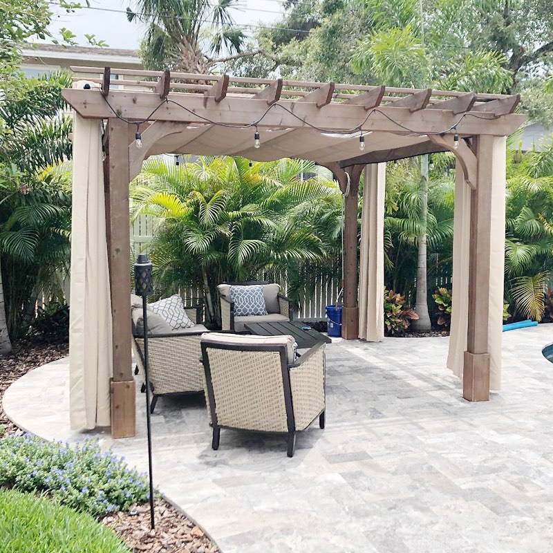 Outdoor curtain fabric panels on a bright patio