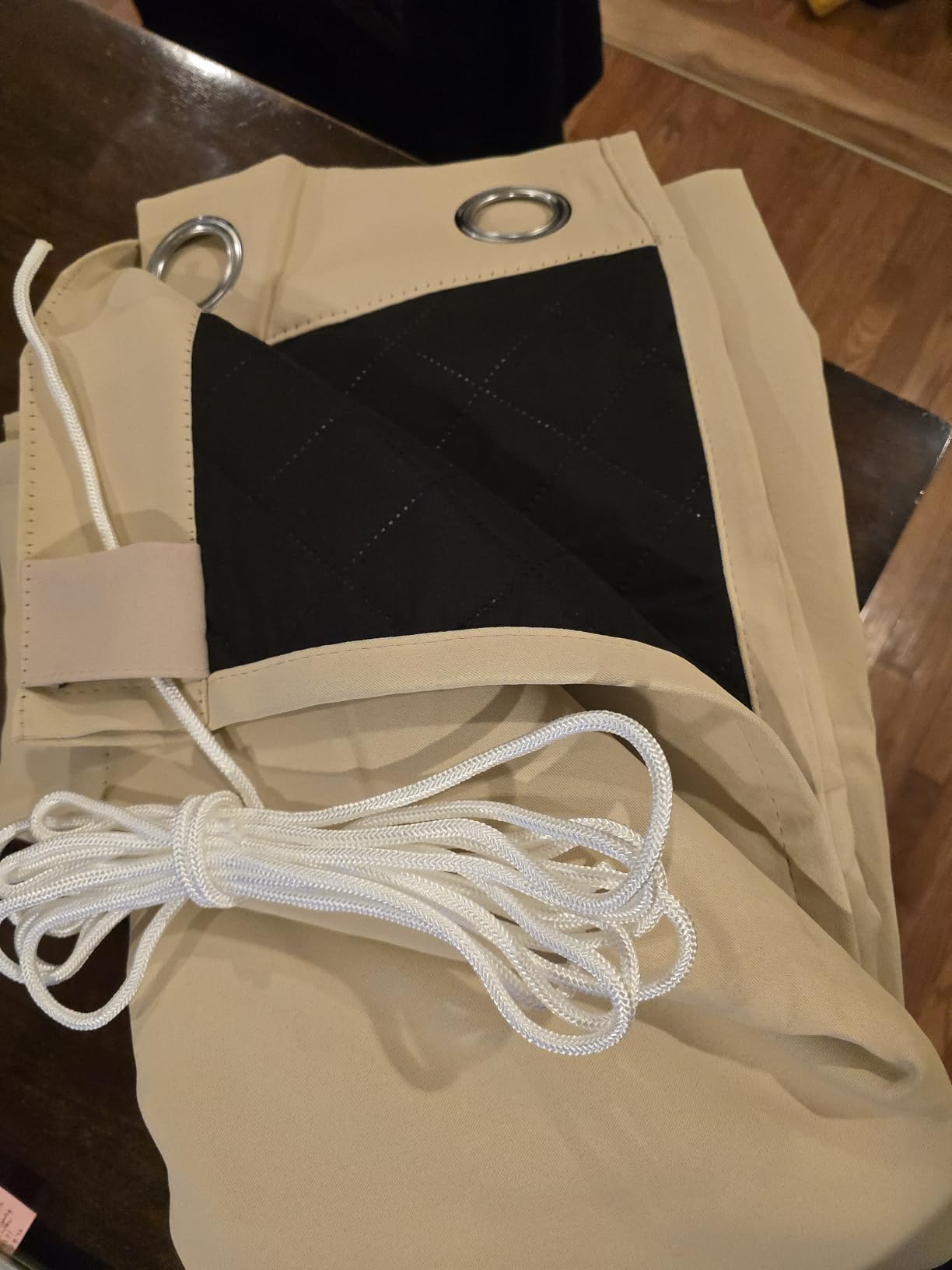 Beige and black insulated outdoor curtain panels with grommets and tieback cords
