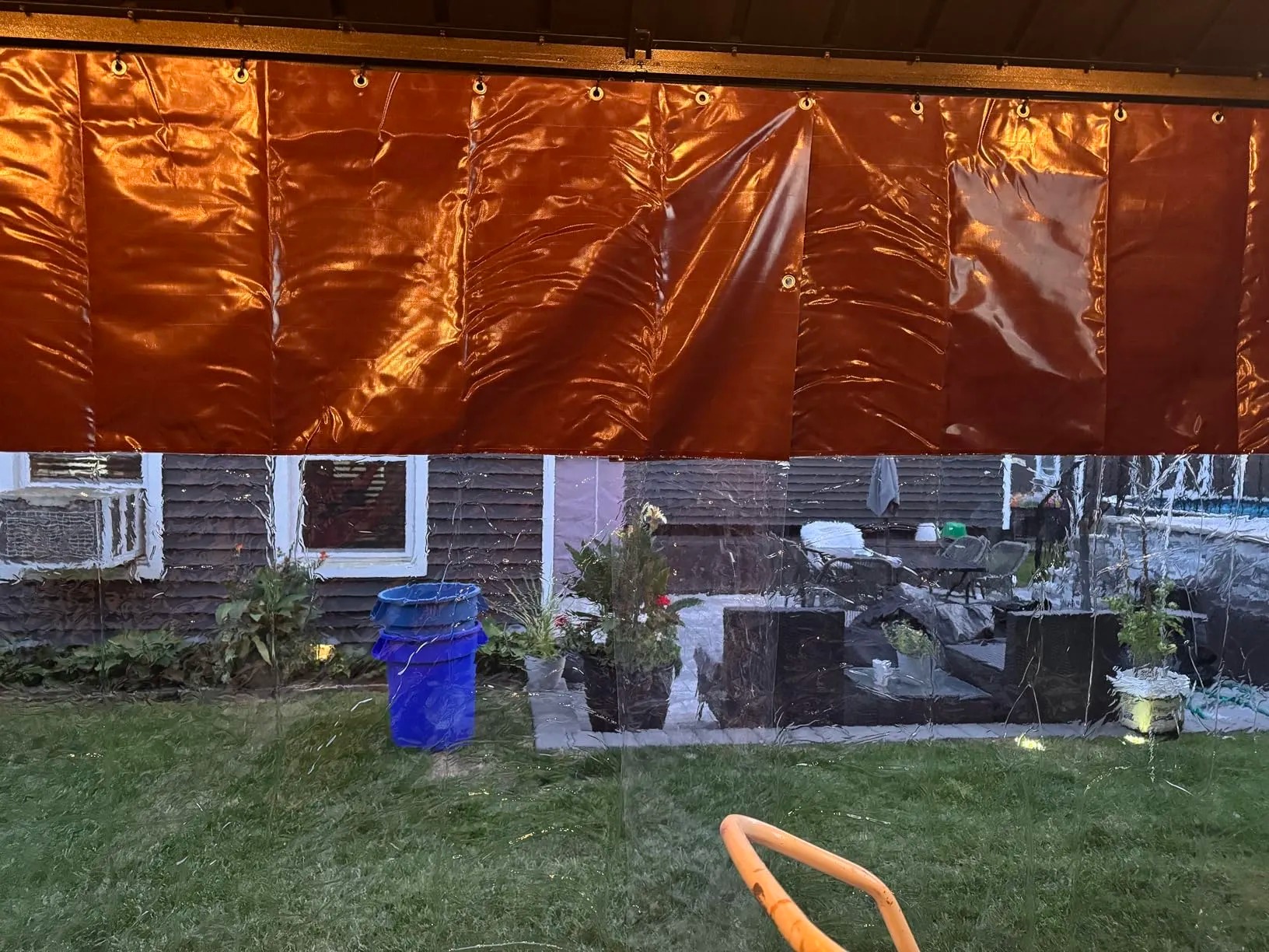 Clear vinyl outdoor curtain panel installed at a covered patio opening