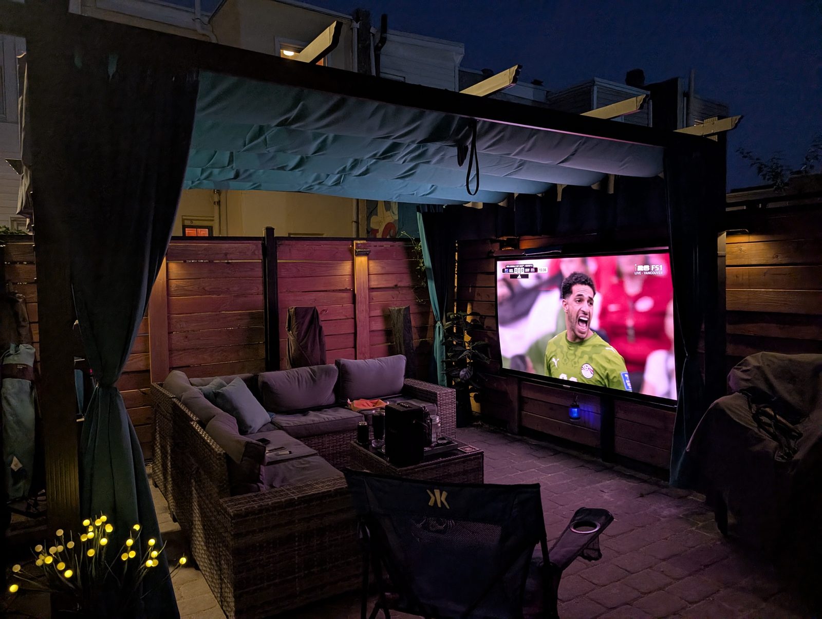 Snowcity outdoor curtains creating a private evening patio lounge with outdoor TV and seating