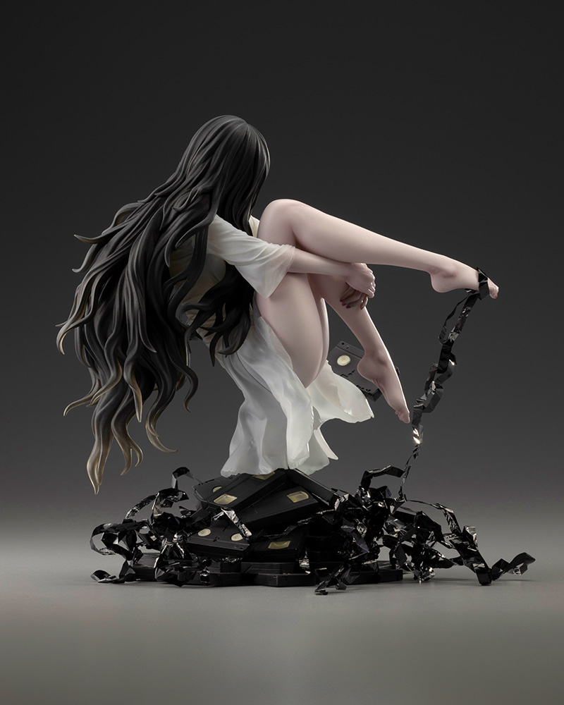 Back view of the Sadako HORROR Bishoujo figure showing her long wavy black hair, a floating videotape and ribbons of tape around the base