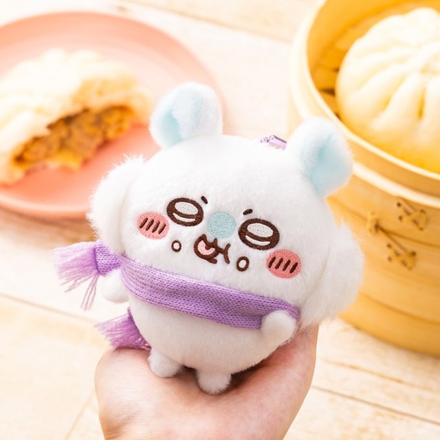 Palm-sized Momonga Eating Meat Bun mascot with purple scarf and ball chain, held above steamed nikuman