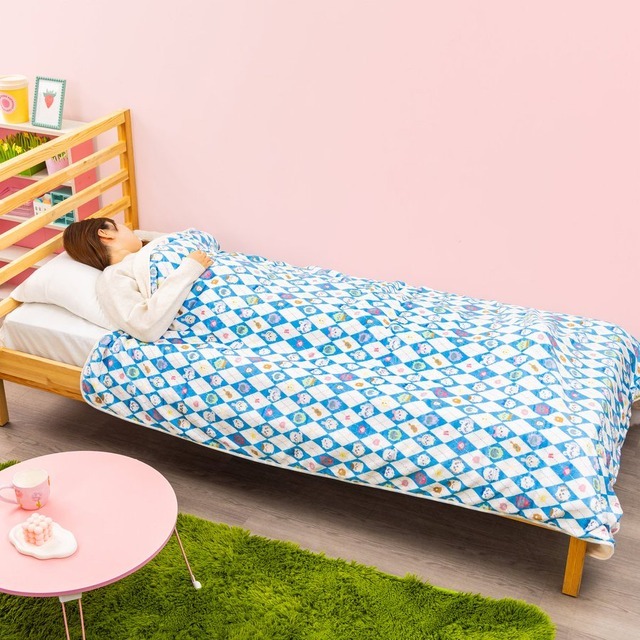Chiikawa oversized throw blanket with blue diamond character pattern covering a bed in a pink bedroom