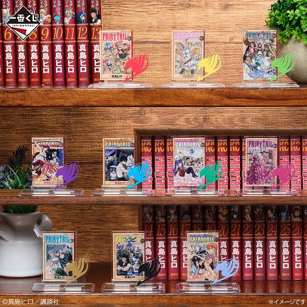 Ichiban Kuji Fairy Tail 20th Anniversary E prize acrylic stands of manga volume covers arranged on a bookshelf