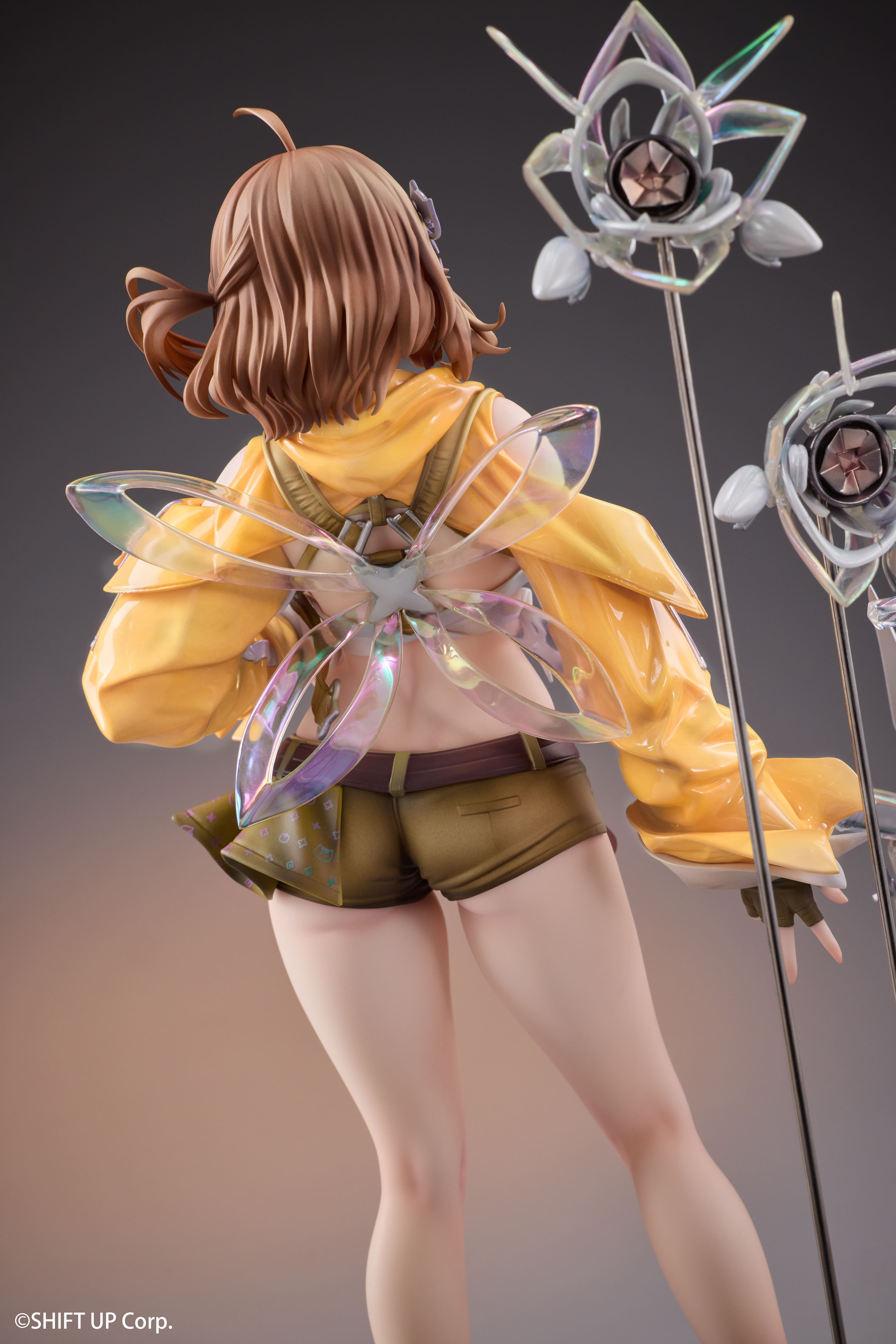 Rear view of NIKKE Anis Star figure with translucent wing pieces and yellow jacket