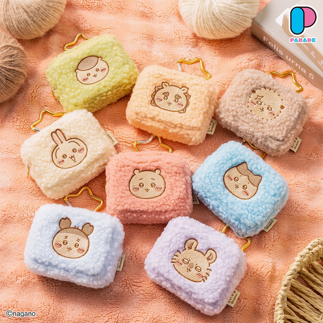 All eight Chiikawa Carabiner Fluffy Pouches in muted pastel colours with embroidered character faces and gold carabiners on a peach blanket